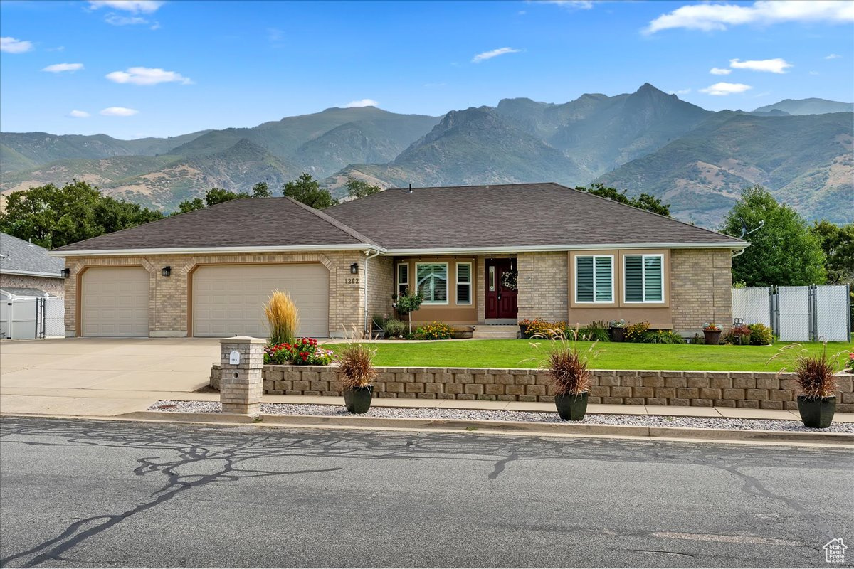 Welcome home to this beautifully maintained 5-bedroom, 4-bath East Layton rambler tucked against the Wasatch mountains. Step inside to an updated kitchen featuring abundant cabinets, under-cabinet lighting, granite countertops, pendant lighting, a large island, and even a built-in desk. The dining nook with a picture window flows into the vaulted family room with a cozy fireplace and access to the large, secluded, covered patio-perfect for relaxing and entertaining. The primary suite offers a spacious retreat with a walk-in closet, double sinks, and a large shower. Two additional bedrooms and a full bath, along with a formal living room and open entry, complete the main floor. The fully finished basement is designed for gatherings and flexibility, boasting a separate TV room, game area, full kitchen, two more bedrooms, and another full bath, plus generous storage and shelving. A half bath off the garage entrance, a large 3-car garage with an extra-long bay, workbench, and overhead storage, plus RV parking, making room for all your toys. Outside, enjoy a fully fenced yard to keep your pets contained, immaculately landscaping that shows true pride of ownership. Water heater, rain gutters, and windows new in last few years. Roof, Furnace, and AC replaced in last 10 years. All this in a prime location-just minutes to HAFB, Hwy 89, shopping, dining, lakes, and world-class ski resorts, and only 20 minutes to SLC Airport. Don't miss your chance to own this East Layton gem! Schedule your private showing today-this one won't last!