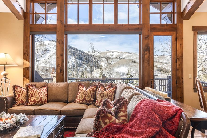 Set within one of Deer Valley 's most picturesque and convenient locations, the exclusive Larkspur townhomes in Empire Pass define an exceptional mountain lifestyle. Rarely available, this Westside residence is discreetly nestled among mature aspen and fir trees, with dramatic views toward Lady Morgan Bowl. Just steps from the Tower Club, Silver Buck ski trail, and Silver Strike chairlift, this coveted mid-mountain location allows owners and guests to enjoy effortless access to First Tracks skiing, well ahead of lower-mountain traffic. Upon entering, guests are immediately captivated by the home's breathtaking views. Designed for maximum comfort and refined mountain luxury, the expansive great room features vaulted, beamed ceilings, a floor-to-ceiling stone fireplace, and a wall of windows that frame unobstructed western vistas. A spacious deck off the great room provides the perfect setting for relaxing or outdoor grilling. The open-concept kitchen and dining area is ideal for both entertaining and everyday living, offering bar seating and a 60-inch round dining table that expands to accommodate up to ten guests. The gourmet kitchen is equipped with granite countertops and premium Viking stainless steel appliances, with the layout allowing the chef to remain connected with family and friends. The main-level primary suite is a private retreat, highlighted by vaulted ceilings, views to the ski slopes, a generous walk-in closet, and a luxurious ensuite bath with a jetted tub and oversized walk-in shower. Three additional bedrooms on the lower level each feature ensuite baths and provide flexible accommodations for family and guests. An upstairs loft offers a quiet office space with ample storage. The lower-level family room is an inviting gathering area, complete with a professional-quality shuffleboard table, 62-inch HDTV, built-in wine refrigerator, and refrigerated drawers - perfect for aprs-ski entertaining. After a day on the slopes, unwind in the private hot tub on the lower stone patio. During summer months, enjoy evenings on the patio around the fire pit while taking in the spectacular night sky. Additional features include a heated driveway and walkway, an attached heated two-car garage, and easy year-round access to mountain amenities. The HOA's complimentary shuttle service provides convenient transportation to Deer Valley and Park City for dining, shopping, and entertainment.