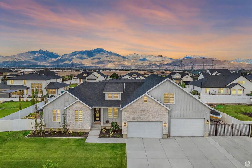 This professionally designed 7-bedroom, 5-bath, 3-family room home combines high-end finishes with thoughtful functionality. The open-concept main level features a huge kitchen with a walk-in pantry, seamlessly flowing into the living and dining areas-perfect for entertaining. The large master suite boasts a luxurious en suite bath, while the oversized laundry room and home office add everyday practicality. The fully finished basement includes a second full kitchen, a mother-in-law apartment, and an additional laundry room, making it ideal for extended family or guests. The spacious 6-car garage-40' deep-offers ample room for vehicles, storage, or a workshop, complemented by RV parking for added convenience. Step outside to a covered deck with an outdoor kitchen featuring a grill, fridge, pizza oven, and Blackstone grill. Enjoy the outdoor firepit, large play set, and planter boxes-all designed for year-round enjoyment. Located close to shopping, dining, and entertainment, this property is perfect for families or anyone who loves to host.