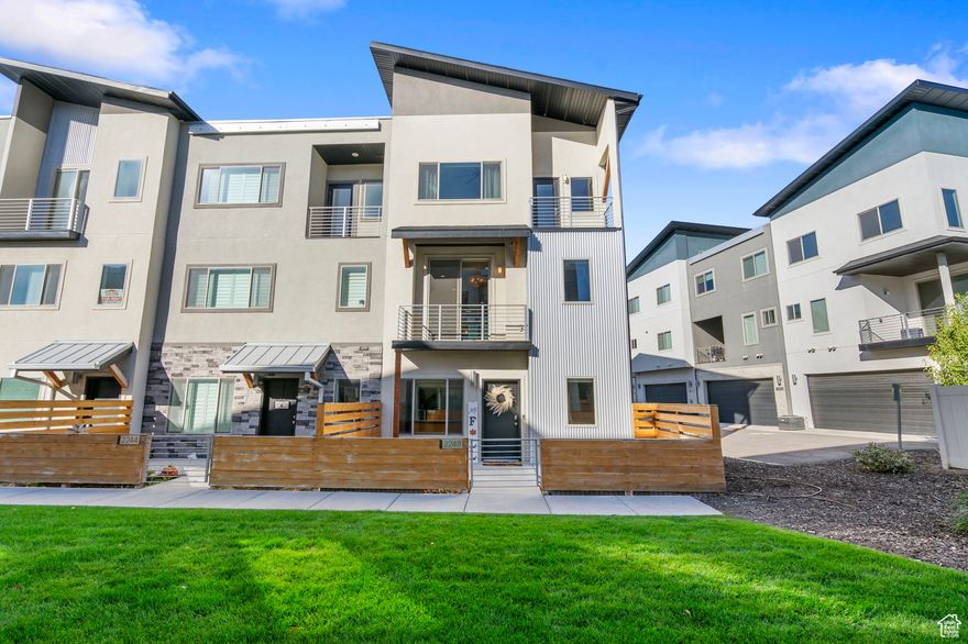 This stunning home is packed with upgrades and thoughtful design details throughout.  Offering 4 bedrooms, 2 full baths, and 2 half baths, it features an open-concept floor plan with designer finishes and custom lighting in every room. The kitchen is a showstopper, featuring upgraded 3" quartz countertops with waterfall edge, ceiling-height cabinetry, and a spacious island perfect for entertaining. The living room showcases a sleek modern gas fireplace and opens to a balcony, while a second living area provides flexibility for an office or additional gathering space. Upstairs, the primary suite impresses with soaring ceilings, abundant natural light, and private balcony access. Enjoy solar-paneled electric shades on the upper windows and blackout roller shades in all bedrooms for restful nights. The primary bath features a large soaking tub, separate shower, and custom tilework throughout. Additional highlights include: Designer Milton & King professionally installed wallpaper; Ceiling fans in all upstairs bedrooms; Upgraded vanities with medicine cabinets for extra storage in two bathrooms; Smart home system plus security; Surround sound in Livingroom; Drip system in enclosed patio; Tankless water heater for on-demand efficiency; Built-in garage shelving for organized storage.  Enjoy all the community amenities, including a pickleball court, playground, and picnic area-perfect for outdoor fun and relaxation. This home truly has it all-luxury, comfort, and modern convenience in every detail.