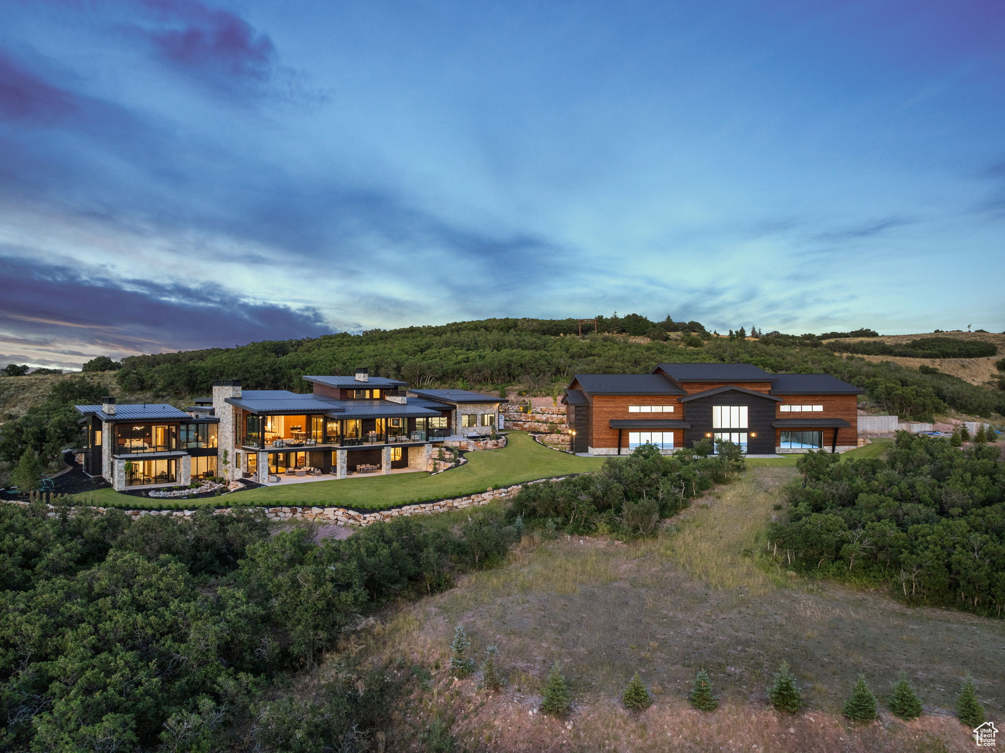 Perched on 24.68 acres in the gated Ranches at the Preserve-one of Park City's most private and expansive neighborhoods-this newly built estate, including a separate structure with indoor tennis court, is a rare combination of seclusion, sophistication, and proximity to everything Park City has to offer. Surrounded by untouched nature, yet only 10 minutes to Kimball Junction and just 25 minutes to Historic Main Street, this legacy property offers the best of both privacy and convenience. Crafted for luxurious main-level living, the 10,954-square-foot residence showcases striking architectural design and refined craftsmanship throughout, from custom cabinetry and woodwork to curated designer lighting and finishes. An expansive great room with vaulted ceilings and a wall of glass that opens at the push of a button invites the outdoors in, framing panoramic views of the Wasatch Mountains and ski resorts. Multiple outdoor living spaces provide unforgettable backdrops for entertaining or relaxation. At the heart of the home is a stunning chef's kitchen, designed with both form and function in mind. Two oversized islands provide ample space for cooking and gathering, while a fully equipped butler's pantry ensures seamless entertaining and storage. The primary suite is a private sanctuary with spa-caliber amenities, generous closet space, and private terrace access. For focus and productivity, enjoy a private executive office and a fully equipped conference room, also ideal as a second office, both enhanced by expansive mountain views and situated in a private wing inside the house. Additional features include a dedicated exercise room, multiple gathering spaces, and a custom bunk room with eight built-in beds, creating a luxurious yet practical retreat for guests or family. The showpiece of the property is the 8,907-square-foot indoor sports facility, designed to meet USTA specifications for tennis, with the versatility to accommodate a basketball court or four pickleball courts. Beyond sport, this one-of-a-kind space offers endless possibilities: transform it into a world-class car gallery, private event venue, music and film studio, or a health and wellness retreat with room for a full gym, lap pool, and golf simulator. For outdoor enthusiasts, take advantage of direct access to the Glenwild trail system from your backyard for miles of hiking, biking, and year-round outdoor adventure. For equestrian lovers, there is a large fully irrigated pasture, and the foundation for a stable has already been poured and plans approved by the HOA and county. Wildlife roam freely around the estate, enhancing its sense of escape, while everyday conveniences remain close at hand. Skiers will appreciate being within 20 minutes of Park City Mountain, Deer Valley, and only 10 minutes from Woodward resorts. 5 minutes from the private Glenwild Golf Club-Park City's premier country club offering world-class golf, dining, and amenities-and only 30 minutes from Salt Lake City International Airport and the vibrant downtown Salt Lake City.