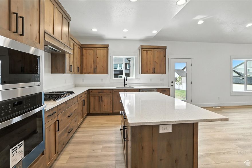 This stunning move-in-ready home boasts vaulted ceilings and a beautiful entryway into the living area. The kitchen is equipped with custom cabinetry, a gas stovetop, a built-in oven, a microwave, and quartz countertops. The main bedroom and bathroom include a separate tub and shower, along with a walk-in closet. Two additional bedrooms on the main floor offer large closets and share an extra bathroom. The spacious garage fits four cars, with the third car garage featuring an oversized door and a 240-volt outlet. Fully insulated and painted walls complete the garage. The unfinished basement offers a blank canvas, ideal for creating the space of your dreams.  Square footage figures are provided as a courtesy estimate only and were obtained from building plans.  Buyer is advised to obtain an independent measurement.