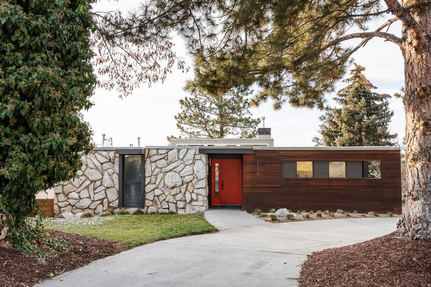 Straight lines are overrated. In a world of boxy renovations curve appeal, at 2136 Elaine Drive throws a beautiful curveball-literally. Perched on Bountiful's coveted East Bench, this 4-bedroom home is a masterclass in organic architecture. The first thing you'll notice is the striking curved faade, a blend of warm cedar and stone that softens the home's profile against the mountains. But this isn't just for show; that architectural rhythm flows right through the front door. Inside, the interior walls mimic those exterior curves, guiding you through the space in a way that feels intentional and seamless-even down to the walkout basement. It's a detail you rarely see, and it gives the home a custom, designer feel that is impossible to replicate. The layout has been smartly reconfigured for modern life. We're talking about a dedicated home office (essential), a proper mudroom (a life-saver), and a surprising amount of storage tucked away exactly where you need it. With a mix of baths-including a full, a three-quarter, and a half-bath-morning traffic jams are a thing of the past. While the front yard serves up major curb appeal, the backyard offers a different kind of opportunity. With sturdy retaining walls already in place, the hardscaping is done, leaving a blank canvas for your own vision-whether that's a minimalist xeriscape to match the mid-century vibes or a lush garden to frame the view. This is a home with good bones, great flow, and a distinct personality. Let's get you home.