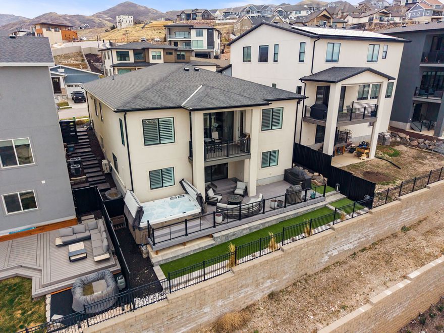 **ATTRACTIVE Price Adjustment; You have to see this home!!** Sitting on the east bench of North Salt Lake, this rambler features stunning views, views, views! Two large deck systems, oversized swim spa (included), firepit, and massive vinyl sliders create the perfect atmosphere to relax or entertain friends and guests with ease! As you walk in, you will immediately notice the gorgeous solid surface flooring the runs throughout the home. Plantation shutters adorn the windows. Automatic sun shades along the backside of the home. Tall ceilings with abundant can lights and other stunning light fixtures. There are two kitchens in this home. The main level kitchen features lovely quartz countertops, floor to ceiling cabinets (with lighting) stainless steel appliances (gas range), and eye catching pendants. The main level primary ensuite has its own amazing views, access to the deck, dual sink vanity, large walk-in closet (professionally built out/organized), and fantastic walk in shower. This home works great for that single person or a couple of professionals. Bedroom 2 (main level) has been built out as an office/study/den and provides an amazing place to work from home. Bedroom 3 (main level) doubles as a guest room with it's own murphy bed, and also had built in cabinetry for that craft room/secondary office. As you make your way downstairs, this gem of a home just keeps giving. Open concept layout, with a tastefully designed entertaining wet bar, a over sized workout/gym (could easily be turned back into a massive bedroom), and spacious family room, and is graced by a slider that opens out to a breathtaking view, yet still maintaining a surprising amount of privacy. Don't forget the spa style walkin shower and tub ensuite where luxury is just the beginning. There is zoned AC/Heating in the basement that is efficient and works really well. Even the garage has custom built-ins and floor coatings. This is one of those homes that has had so much money poured into it to create a quality and highend finished delight. You have to walk it and see it to understand the quality you get for the money here. Shows REALLy well. It won't disappoint! All furniture/TVs can be negotiated to be included at the right terms.