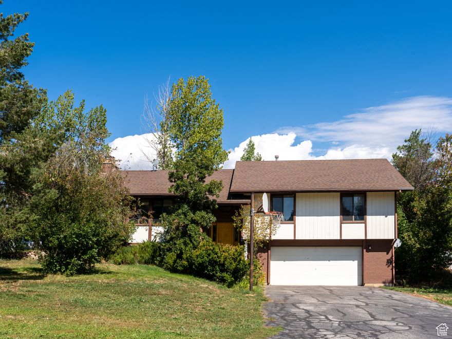 Opportunity knocks with this split-level home in a highly desirable neighborhood. Surrounded by mature trees and offering great views of Nordic Valley Ski Area and surrounding mountains this property provides privacy, shade, and a spacious yard with plenty of room to garden, expand, or entertain. Open space on the east side of the property. Located in a great neighborhood, the home features vaulted ceilings, a dramatic floor-to-ceiling stone fireplace, and large windows that fill the space with natural light and abundance of storage. The kitchen offers warm oak cabinetry, ample counter space, and a breakfast bar-ready for a modern refresh to unlock its full potential. A new roof was installed in May of 2024, providing peace of mind and added value for years to come. Whether you're an investor or a homeowner ready to personalize your space, this property offers great potential in a location that's hard to beat. All property information, boundaries and documents to be verified by buyer.