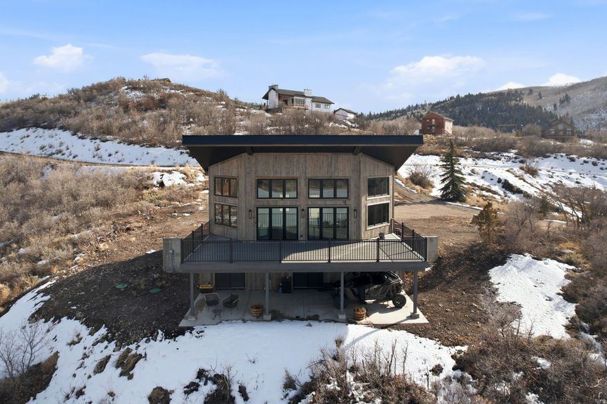 Lake views, access to the Uinta National Forest, and sweeping Wasatch Back scenery define this brand-new modern mountain retreat in Timber Lakes Estates. Experience the ultimate Heber Valley escape in this newly completed cabin overlooking Witt's Lake, where panoramic views, towering trees, and peaceful alpine surroundings create the perfect year-round retreat. Offered furnished, this home is truly turn-key and ready to enjoy. The expansive 1,000 sq ft Trex deck captures stunning lake and mountain views-ideal for entertaining or relaxing while watching the lights of Mayflower and Deer Valley glow in the distance. The main level features an open-concept design with dramatic floor-to-ceiling windows that fill the home with natural light while framing the surrounding landscape. The lower level includes three bedrooms, two full bathrooms, and multiple sliding glass doors that open to a covered patio with beautiful lake and mountain views. Situated on a 1.2-acre flat lot, the property offers excellent potential for a future garage or guest house. Timber Lakes Estates is a private, guard-gated mountain community just 7 miles east of Heber City, offering lake views, towering aspens, and direct access to thousands of acres of national forest. Located just 12 minutes to Heber, 30 minutes to Park City, and approximately one hour to Salt Lake City or Provo, this property provides convenient access to world-class recreation, including skiing, golf, fishing, boating, hunting, ATV riding, and endless outdoor adventure throughout the Heber Valley and Park City areas.