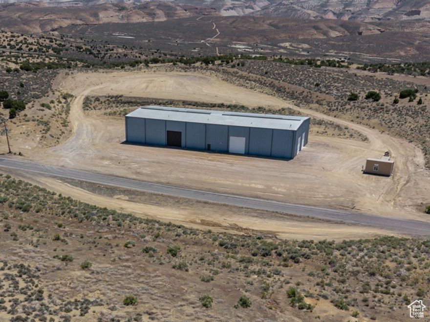 Located in the heart of the oil field this 15,000 sq ft building provides a unique location to provide a hub for your offsite needs while still staying in the field. The heated and insulated building boasts two restrooms and an office space, with plenty of warehouse space for storage and workspace out of the elements. Located on a 5 acre lot providing plenty of parking space with across the street turn out. There is also an additional 35.00 acres available to lease behind the building that can be built to suit for a large storage yard. (MLS# 2093359) So many possibilities.