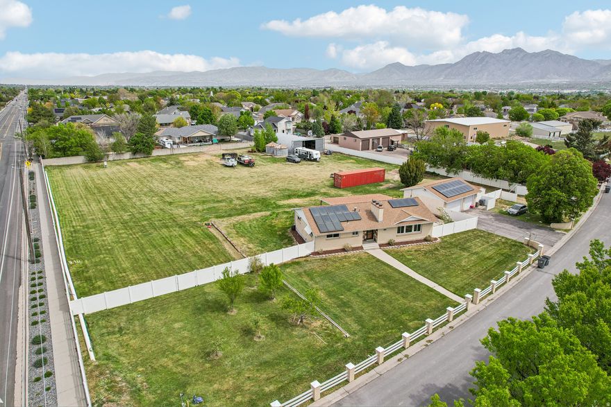 Exceptional 1.9-acre corner estate in the prestigious Bonanza Acres community. This premier horse property offers an unmatched combination of scale and privacy in South Jordan, featuring 1.6 irrigation water shares and a fully fenced perimeter. The home is meticulously maintained with significant updates, roof 2018, windows front of house 2018. The interior is highlighted by a modern kitchen with beautiful stone countertops, a spacious primary bedroom retreat, and two inviting fireplaces. Owned active solar ensures modern efficiency throughout. Exterior amenities include an oversized detached 2-car garage with extra width and a substantial outbuilding. Anchored by two signature silos and featuring expansive RV parking, this property provides fantastic equestrian potential.