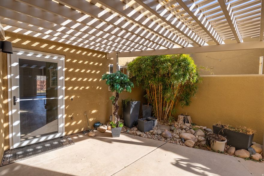 Welcome to this well kept  2-bed, 2-bath townhome in the Orchard Villa community, where an open-concept layout is elevated by vaulted ceilings and updated LVP flooring throughout. The primary bedroom features a charming barn door that opens to a private bathroon and walk-in closet. The guest room has a built-in Murphy bed that can easily transform the space from a bedroom to a home office. Before entering the home, you're greeted by a private gated courtyard complete with custom lighting, a sturdy metal pergola, and a dedicated gardening area with a hose bib. Out back, the living space extends through sliding glass doors to a covered patio-the perfect vantage point for iconic red rock sunsets and quiet evenings. Enjoy extra storage in the 2-car garage with built-in shelving. The community also has a pool just a short walk away. Nightly renting is not permitted.