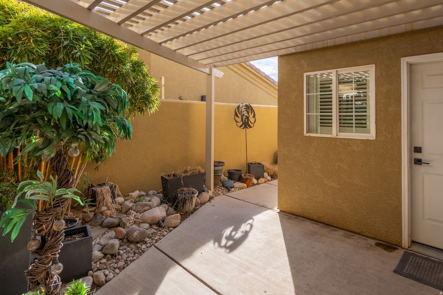 Welcome to this well kept  2-bed, 2-bath townhome in the Orchard Villa community, where an open-concept layout is elevated by vaulted ceilings and updated LVP flooring throughout. The primary bedroom features a charming barn door that opens to a private bathroon and walk-in closet. The guest room has a built-in Murphy bed that can easily transform the space from a bedroom to a home office. Before entering the home, you're greeted by a private gated courtyard complete with custom lighting, a sturdy metal pergola, and a dedicated gardening area with a hose bib. Out back, the living space extends through sliding glass doors to a covered patio-the perfect vantage point for iconic red rock sunsets and quiet evenings. Enjoy extra storage in the 2-car garage with built-in shelving. The community also has a pool just a short walk away. Nightly renting is not permitted. This property is in a community reinvestment area and qualifies for a community reinvestment act mortgage loan (CRA). As little as 3% down. To prequalify for special financing, contact listing agent.