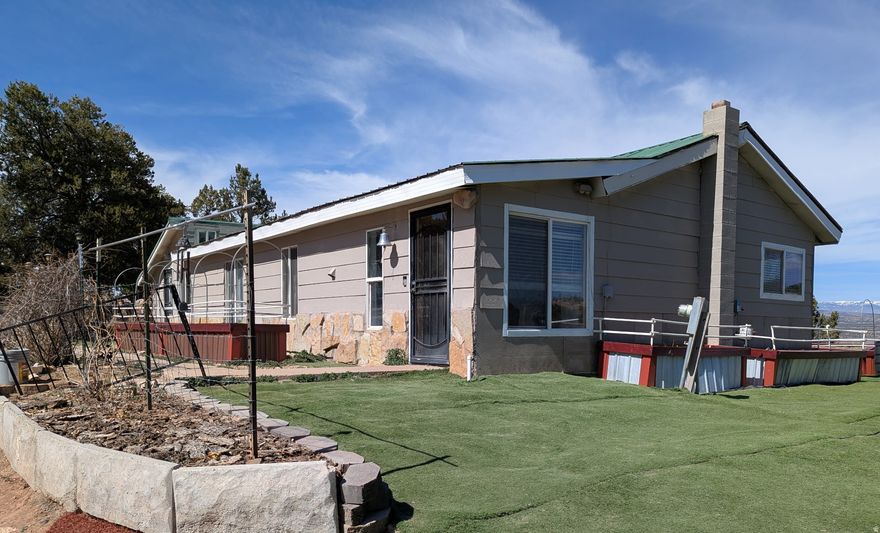 Wake up to mountain views, roaming wildlife, and wide-open space. This peaceful country property sits near the Tabby Mountain winter range and Division of Wildlife Resources, offering front-row access to deer, elk, ATV trails, and endless outdoor recreation. Five reservoirs and the Strawberry River are all within 30 minutes, making this an ideal setting for fishing, boating, and adventure. Evenings are best spent on the west-facing deck beneath the pergola, watching the sunset over the High Uinta Mountains as hummingbirds fill the air. Inside, the home features a spacious living area, a kitchen with both a propane stove and working wood cook stove, and a large root cellar for storage. Two bedrooms include Murphy beds for flexible use, while the primary suite offers a half bath and built-in craft space. The fully fenced homesite provides privacy and room to roam, complete with a large insulated shop, outbuildings, dog run, and space for projects or storage. Across the road, four fenced acres offer rotating pastures, a barn, hen house, and commercial greenhouse, perfect for horses, animals, or hobby farming. With county-maintained access, nearby school bus service, and unmatched scenery, this property delivers the freedom, privacy, and lifestyle that country living is all about!