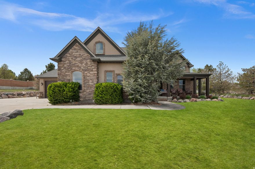 A storybook estate set on a serene 1.0 acre lot with Wasatch views peeking through every front window. The grand entry invites you in, where a floor-to-ceiling double-sided fireplace anchors the thoughtfully designed main level featuring a stunning kitchen with custom cabinetry, granite countertops, walk-in pantry, generous gathering spaces, and a den just off the entry. The main floor primary suite delivers everyday luxury with custom lighting and an expansive bath featuring a Euro-glass surround shower, separate corner soaking tub, dual vanities, private toilette room, and a large walk-in closet, all complemented by the convenience of main floor laundry. The fully finished basement apartment walks out to a large covered patio and offers its own kitchen, dining, living, two bedrooms connected by a full bath, an additional powder room, fireplace, and abundant storage, creating exceptional flexibility for real life. Upstairs, two additional primary suites, each with en-suite baths and impressive walk-in closets, plus a flex room and reading nook, provide space for everyone to spread out. The oversized garage easily accommodates two full-size trucks with room for a workspace in the same bay. Outside, a massive sunset-view deck overlooks the fully landscaped yard with striking rock features, waterfall, and fruit trees. Increasingly rare, this property is ready for horses, a barn, detached ADU, or simply room to roam and bring your vision to life. Welcome to 15056 Pastoral Way-where everyday living feels quietly extraordinary.