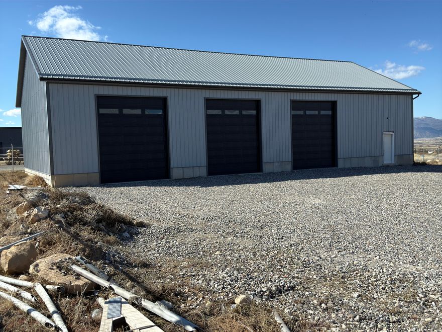 Hard-to-find 40' x 80' clear-span shop designed for flexible end-user buildout. Three 12' overhead doors with quiet wall-mounted openers make the building very functional for contractor, fabrication, storage, or service-based uses. Electrical is already installed and building is pre-plumbed for a future bathroom, helping reduce initial improvement costs.  Portion of the building is framed with attic-style trusses, creating a strong opportunity for future two-story office buildout or mezzanine storage depending on user needs.  Property is accessed through a shared gate with full gravel drive access suitable for trucks, trailers, and equipment. Western boundary sits adjacent to Contoy Arena, and access is via a former airport runway that now serves as a standard private access road.  Water is available in the area for future connection. Three-phase power appears to be located near the property corner, offering potential for higher power users (buyer to verify connection details).  Excellent opportunity for owner-users wanting a functional shop today with the ability to customize interior buildout over time. Contact listing agent for gate access and showing coordination.  Square footage figures are provided as a courtesy estimate only and were obtained from Realtor Measurements.  Buyer is advised to obtain an independent measurement.  No Personal Property will transact with this sale.  All items will be removed prior to property transfer.