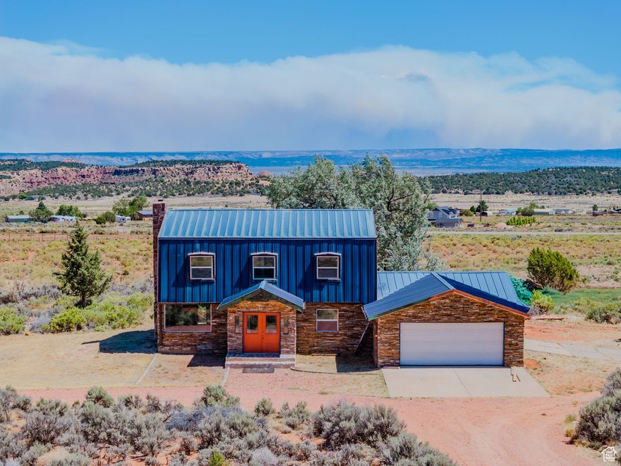 This unique home on 6.84 acres is full of artistic flair & personality. When you enter through the French doors, you'll notice handcrafted touches-like beautifully restored doors, upcycled from Kanab legend Paula Zutes. The spacious living room invites you to cozy up by the wood stove while taking in stunning views of the Vermilion Cliffs. Step out back to a patio, perfect for morning coffee, sunset dinners, or stargazing. At the heart of the home is a kitchen with granite countertops, a copper backsplash, and a hammered copper sink,  a main floor custom 1/2 bath and laundry room.  Just off the kitchen, a large family room leads you out to the horse corral. Upstairs, you'll find three bedrooms and two bathrooms with thoughtful details: tiled showers, dual vanities with copper sinks in primary bath, and big windows to flood the space with natural light. Bonus room in the basement with large utility room. Maintenance free exterior with Quartzite stone & metal siding. Zoning allows for a second home. There's more than enough room here for multi-generational living PLUS all your animals! BLM access is incredibly close, giving you ample recreation opportunities! (Buyer to verify all)