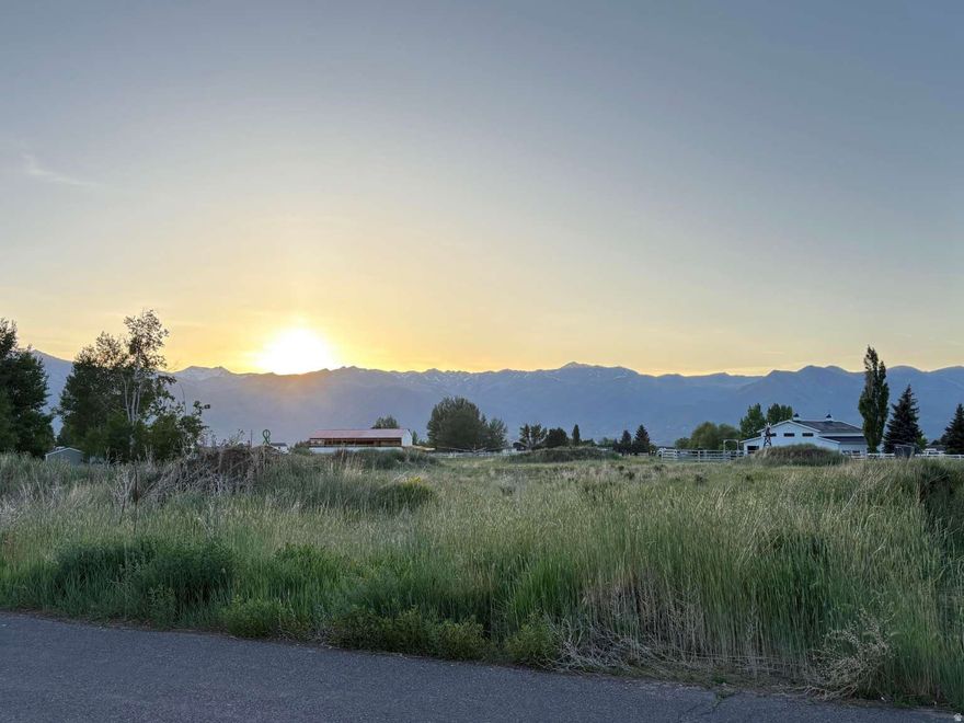 MUST SEE 2+ acre lot in rural Heber. Animals welcome. Sunsets over Timpanogas. Amazing neighbors. NO HOA Fees or crazy building rules. Quiet neighborhood with NO traffic running through it. Quick access to the highway. Includes 2 water shares and is ready to build on! This property has amazing neighbors on all 3 sides of it. As you can see from the Google map image, I had plowed a driveway along one side of the property to go to the back of the property and filled it in with road base. The topsoil was scraped and placed in a couple of piles on the property for use in the future yard.  When we purchased the property it did not have water shares with it. By the time we were able to track them down, we had purchased a different lot and drew up plans. If you are looking for a quiet country neighborhood without being far from town, THIS is the place!