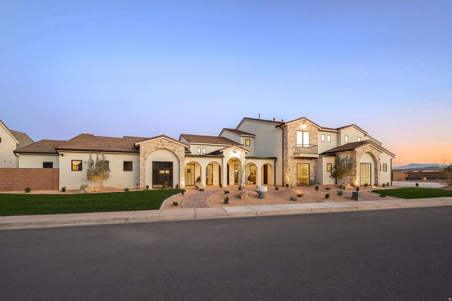 Introducing Playa Del Sommer, a stunning 2026 Parade Home built by Slate Ridge Homes, offering 8,352 square feet of refined indoor and outdoor luxury living in one of Washington County's premier communities. Showcasing timeless Spanish-inspired architecture, warm textures, rich finishes, and cutting-edge smart home technology, this extraordinary residence sets a new standard for Southern Utah luxury. Thoughtfully designed with both comfort and entertaining in mind, the home features 7 bedrooms, 8 bathrooms, and a 8-car garage. Expansive living areas flow effortlessly throughout the home, anchored by a grand great room that creates a seamless connection between indoor and outdoor living spaces. The well-appointed floor plan includes a private office, exercise room, dedicated theater, game room, and an oversized bunk room featuring a built-in two-story playhouse and slide, offering exceptional areas for work, wellness, entertainment, and hosting family or guests. Each bedroom suite is designed with privacy and comfort in mind, making the home ideal for multi-generational living or luxury retreat-style gatherings. At the heart of the home, the gourmet kitchen features professional-grade appliances, custom cabinetry, and an elegant layout designed for effortless entertaining. Large gathering spaces extend outdoors to a beautifully designed retreat, complete with a resort-style pool, private putting green, and inviting lounge areas perfect for relaxing or entertaining against Southern Utah's breathtaking red rock backdrop. Exceptional craftsmanship is evident throughout, with handcrafted details, quality materials, and timeless architectural elements that embody true Spanish elegance while delivering the sophistication and comfort of modern luxury living.