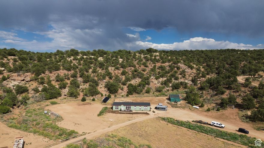 Welcome to your dream homestead! Blm land backs up to the front and back of property. Private land on the sides. Nestled in a cove surrounded by a bluff with 40 acres of riding and hiking just outside your back door! Main house with 4 other parcels equaling 60 acres awaits your family. Main house has  9' raised walls and vaulted ceilings, with huge windows flooding the home with natural light and stunning views. Rocky mountain package includes extra insulation and extra sealing throughout. Energy star package,  LED lighting throughout. Cement hardy board siding (fireproof). Bronze fixtures throughout. Upgraded kitchen with smugglers pantry,  pot filler, stainless appliances and a farmhouse sink. Propane appliances and furnace. Master bath has freestanding jet tub, walk in shower, ceiling fan. Double vanity with raised drawer bank. Second family room, office or den that is currently being used as a salon. Extra large laundry room with island and cabinets throughout including a sink.  Whole house solar system with wind turbine, 1500kw powerhouse liquid cooled diesel engine factory converted to propane generator that recharges batteries in case of several days of no sun, or oversized load on system. New front and back deck, a 30x30 Pole barn with freeze free year round water, a 30x50 shop has a two post, 10klb brand new hoist. The shop has solar and wind power as well as, 2-  10' and a  1- 12 ' roll up doors. . Also offering a backhoe, 2 dump trucks a small tractor and other farm items to set yourself up for self sustaining complete off grid living. A 2 bed 1 bath mobile home for possible rental or guest house or multi generational family.  Square footage figures are provided as a courtesy estimate only and were obtained from county records.  Buyer is advised to obtain an independent measurement.