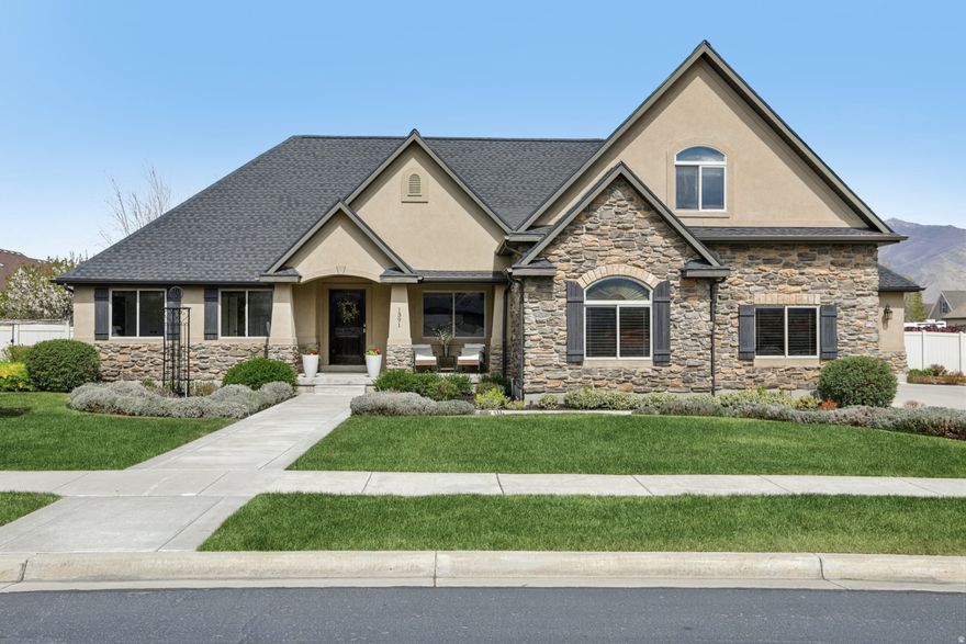 Stunning 5-bedroom, 3-bathroom home in a prime Spanish Fork neighborhood.  Set on a spacious 13,765 sq ft (0.32-acre) lot, this home offers 4045 total sq ft (2,242 sq ft of upgraded living space and an expansive unfinished 1,803 sq ft basement ready for your vision). Plus a fully finished 1,021 sq ft 3-car garage. Discover premium finishes throughout, including Alder custom cabinetry, granite countertops, and premium engineered hardwood floors. The gourmet kitchen features bar seating, upgraded stainless-steel, bespoke, smart appliances, and abundant storage-perfect for family meals and entertaining. A cozy gas fireplace anchors the open-concept living areas, while natural light pours in from large windows overlooking the backyard oasis. The primary suite boasts a luxurious bath with a garden tub and separate shower, plus a generous walk-in closet. Two additional bedrooms, full bathroom, office / living room, entry foyer, a laundry with a sink and a mudroom with floor-to ceiling storage complete the first floor. Upstairs are two additional bedrooms each with their own walk-in closets, a bathroom with a private toilet / tub area and two large hallway closets.  Smart-home technology enhances everyday living: updated lighting throughout the house, built in Bose speakers, a Rachio smart sprinkler system linked to the local weather station, 11 smart lighting switches, video doorbell, smart thermostat, two smart assistants, and two outdoor security cameras. The city provides fiber-optic internet.  The two-car garage is extra wide, while the third garage comes complete with a slat wall organization, abundant storage shelving and a hot / cold soft water faucet-perfect for washing off the car. All garage spaces are fully finished. Recent major investments add peace of mind and value: Complete roof replacement in 2024 (new shingles + continuous ridge venting ($32,000). Additional 30 bags of Climate Pro fiberglass blown-in attic insulation for superior energy efficiency. The architect-designed backyard is a true resort perfect for entertaining. Entered through a custom-made iron gate, it boasts a spacious stamped concrete patio, large deck with extra wide stairs, a low wall, and ten trees. Sitting on the deck, the mountain view to the east is breath-taking. Tucked into the side yard are garden boxes, a compost bin, and grape vines. Two of the trees bear fruit: cherries and golden delicious apples. The landscaping includes electrical outlets, pre-wired landscape lighting, and five additional water spigots and thirteen more trees in the front of the house. Plus a wrap-around driveway, a sweeping lavender hedge and blooming ground cover beneath the groves. Additional highlights include close proximity to the Canyon Creek Parkway shopping district, including a Costco, Target, Walmart, Lowes, Hobby Lobby, gym, several places to eat, and a hospital. The house is just one mile from where the new Spanish Fork Temple of The Church of Jesus Christ of Latter-day Saints will be built. Spanish Fork also offers many parks, including a spacious sports complex, a web of walking paths, and brand-new fitness center/water park.  This move-in-ready home combines modern conveniences, thoughtful storage solutions, and exceptional outdoor living in one of Spanish Fork's most desirable areas. Don't miss your opportunity to own this standout property-schedule a showing today!