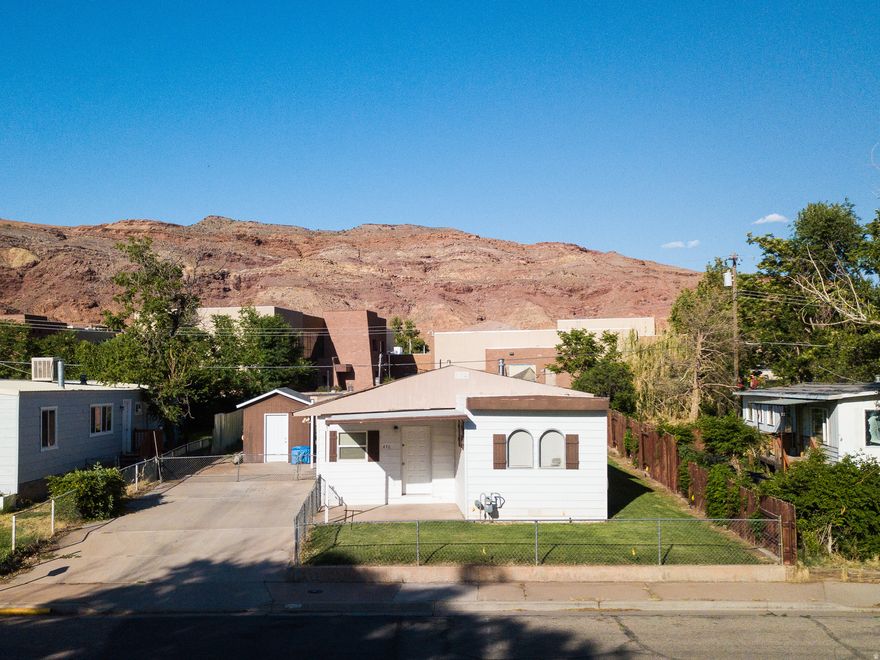 Mostly furnished, move-in ready Moab home with a main 2-bed, 1-bath unit and an attached but separate 1-bed, 1-bath ADU, complete with its own entrance and kitchen! Enjoy a large, naturally lit living room, and many new appliances including two hot water heaters, the fridge and dishwasher in the main house, the washer and dryer, and a natural gas fireplace. You'll love the the outdoor living on the spacious back deck with an attached sunshade, a fully fenced yard, a new roof, and a shed for extra storage. The home is walking distance from schools, a park, and the aquatic center. Square footage figures are provided as a courtesy estimate only. Buyer is advised to obtain an independent measurement.