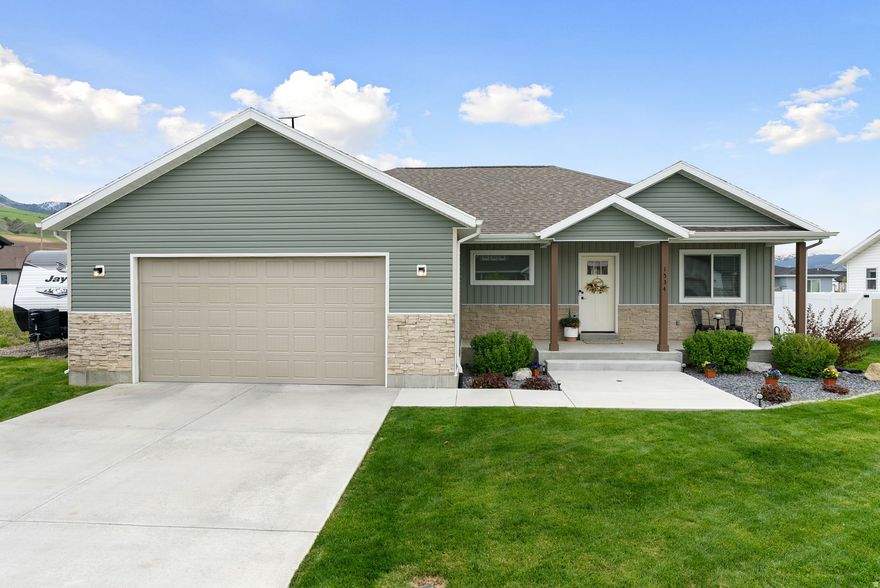 Beautiful home with modern comfort surrounded by BREATHTAKING MOUNTAIN VIEWS. Located in a desirable neighborhood with NO HOA and just minutes from Blacksmith Fork Canyon, the setting is hard to beat. The open layout features a spacious kitchen with a large island, perfect for everyday living and entertaining. The fully fenced backyard provides privacy and sweeping mountain views, where deer and elk can often be seen grazing on the mountainside. The side of the home features a gravel parking area ideal for RVs, trailers, or extra vehicles, in addition to the 2-car garage.