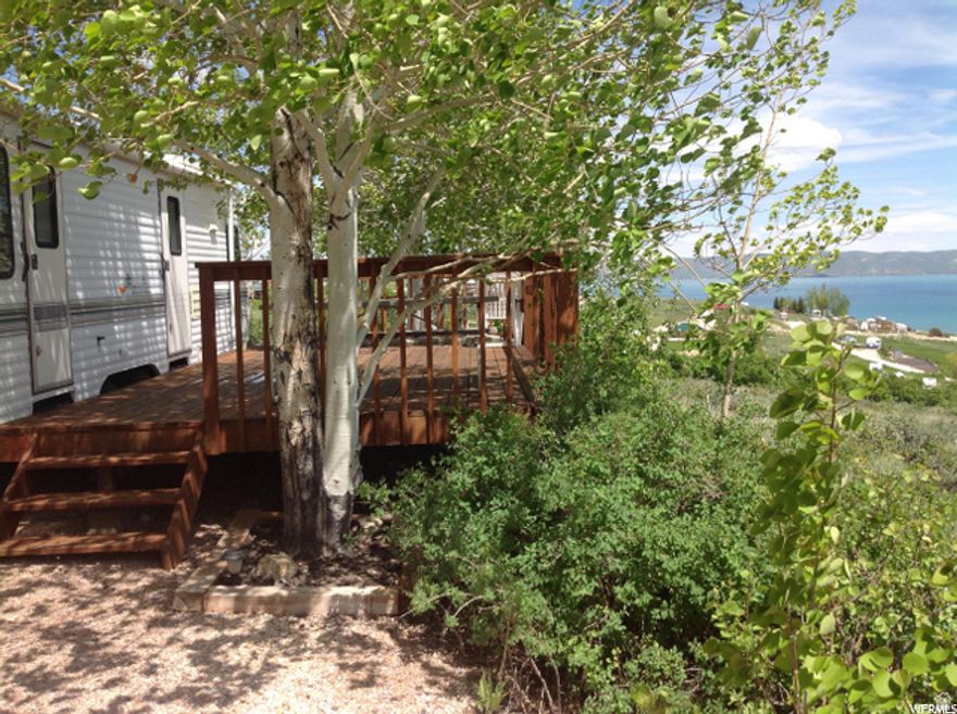Lots 75 & 76 are two of the nicest lots in Bear Lake RV Park. Backed on the north by a huge common area, with spectacular VIEWS of Bear Lake. Lot 75 is fully developed with a 10 x 20 raised deck adjacent to a 1996 Wilderness 30-ft trailer in good condition, a 10 x 12 ground level deck, & 10 x 8 raised deck, with more than a dozen mature trees plus an in-ground fire pit circled by a concrete walk. Trailer & barbecue included.  Lot 76 is undeveloped, but has power. Make this your BEAR LAKE summer get-away! Call listing agent for details.  No Short-Term-Rentals.