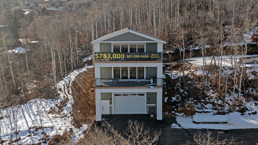 Tucked away in a wooded, private setting, this inviting Bear Lake home offers peaceful surroundings with beautiful lake views enjoyed from two covered balconies. The open kitchen, dining, and living area is designed for gathering, featuring a cozy fireplace and large view windows that frame the natural landscape. A main-level master suite provides comfort and convenience, while the upper level offers three additional bedrooms, a full bathroom, and a second living room with its own fireplace-perfect for relaxing or hosting guests. An extra-long, extra-high garage measuring approximately 30 by 40 feet includes an upper storage room of about 60 square feet, ideal for recreational gear and seasonal storage. The paved driveway and ample parking add ease and accessibility. Outdoor enthusiasts will appreciate the close proximity to The Sinks and Cache National Forest, offering direct access to ATV, UTV, and snowmobile trails, along with opportunities for snowshoeing, mountain biking, and hiking. Beaver Mountain Ski Resort is just 15 minutes away, while Bear Lake State Park Marina and Garden City are only 5 minutes from the property. Two nearby Garden City parks enhance the lifestyle, one featuring a scenic boardwalk to the beach and the other offering a fishing pond and pickleball courts. Please note that short-term rentals are not permitted by the HOA.