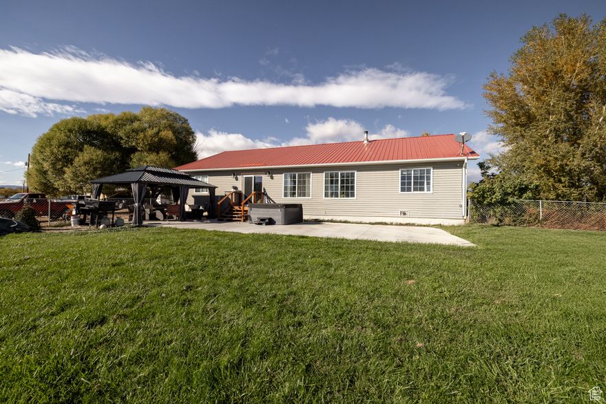 Charming Rural Retreat on 5.22 Acres in Naples, Nestled in the serene landscapes , this expansive 5-bedroom, 2-bathroom home offers the perfect blend of comfortable country living and modern potential on a generous 5.22-acre parcel. This gem provides ample space for hobby farmers  or those seeking a peaceful escape just minutes from Vernal  amenities.  Imagine waking up to breathtaking mountain views framed by mature cottonwood and spruce trees, with vibrant fall foliage adding seasonal charm to your private oasis. The heart of this property is a sturdy, single-level ranch-style home with a striking red metal roof designed for durability in Utah's variable climate. Step inside to discover a spacious, light-filled layout ideal for gatherings, with five generously sized bedrooms offering flexibility for home office, or guest quarters. The two well-appointed bathrooms ensure convenience without compromise, while the open-concept living and kitchen areas invite effortless entertaining.  Outside, the magic truly unfolds across nearly 5.5 acres of  land, blending manicured lawns, natural  creek and open pasture perfect for horses, livestock, or simply stargazing under wide Uintah Basin skies. A detached 2-car garage  provides secure storage for vehicles or equipment, complemented by a large gravel driveway and additional outbuildings for tools and tack.  Buyer to verify all information.