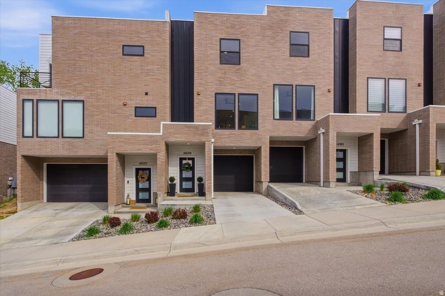 This recently built, move-in ready townhome is located in an up-and-coming Draper location. Perfect opportunity for its next owner to buy for themselves or rent out with no cap on number of rentals within the HOA. Minutes from the Bangerter Highway exit off I-15 allows for easy access to both downtown Salt Lake and Silicon Slopes, while still being tucked on the East side close to the mountains. Plenty of options for outdoor activities with nearby trails, great schools, shopping and dining options a few minutes away.  Just across the freeway from The Point, a development set for completion in the next few years which will add great value to the area. The main floor's open design is enhanced by natural light through big, freshly washed windows, and crisp modern styling. Each space has been maximized for functionality and comfort, from the tiled mudroom by the attached garage to the dual vanity in the primary ensuite with extra large tub.  Each bedroom has its own full bathroom, complete with large closets, walk-in on the upstairs and privacy on the lower level.