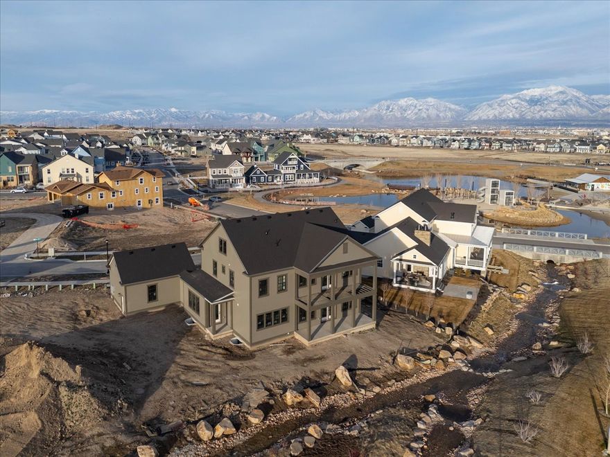 Welcome to your dream home! This Modern Colonial Custom Home offers an impressive 6 bedrooms and 3.5 bathrooms, perfectly designed for modern living. Step into the luxurious primary suite, featuring a vaulted ceiling and a private balcony that overlooks the tranquil Braided Creek.  Set on a generous almost 1/3-acre lot, this home boasts a huge yard, ideal for entertaining or creating your own outdoor oasis. The property is located directly on Daybreak's Braided Creek, providing a picturesque backdrop and a peaceful environment. The open floor plan, crafted by Daybreak's Luxury Builder seamlessly connects the living spaces, making it perfect for family gatherings or entertaining guests. Don't miss this incredible opportunity to own a piece of paradise in Daybreak! Schedule your showing today and experience the elegance and comfort this home has to offer.  Home is expected to be complete by end of March.  Call agent to set up showing.