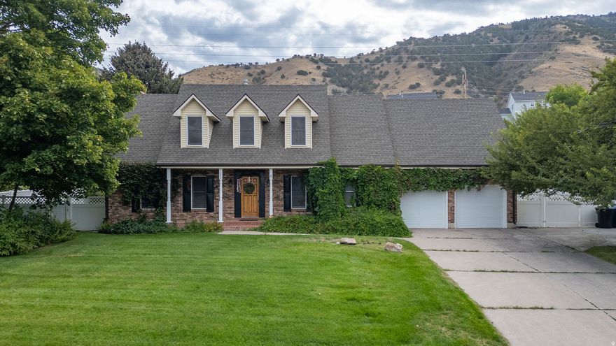 Beautiful 2-story home built in 1983 with classic charm, surrounded by mature vines on nearly a half-acre. Enjoy amazing views of Cache Valley! Remodeled basement with wood stove and great storage. 3 attics! Features include a gas fireplace, step-down family room, new fridge, gas stove, electric oven, new A/C, and new garage door. Fruit lovers will appreciate the apple, pear, and bing cherry trees, plus grapevines, raspberries, blackberries, and rhubarb. Concrete footings under the fence add durability and protection. Great neighborhood, spacious yard, and inviting front porch-this home offers comfort, character, and beauty inside and out! Buyer to verify all. Don't miss the 3D tour