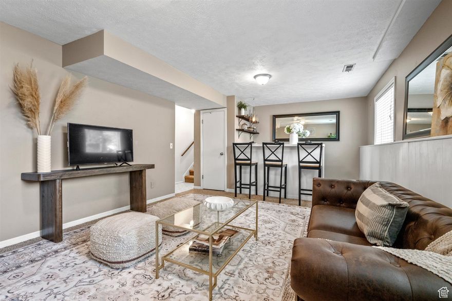 Welcome to this delightful home, perfectly situated on a desirable, large corner lot that offers both spaciousness and privacy. With a two-car garage and dedicated RV parking, there is plenty of space for all your vehicles and outdoor toys. The fully fenced backyard is your retreat, featuring a charming patio ideal for entertaining or relaxing. Additionally, a versatile shed awaits to become your workshop haven or a gardener's potting paradise. The property is adorned with mature trees, offering shade and a picturesque setting that enhances the home's curb appeal. Inside, the main level invites you into a welcoming, spacious living room, a well-appointed kitchen, and a dining area that opens to the backyard patio via sliding glass doors. Venture upstairs to discover three comfortable bedrooms and a full bathroom, providing ample space. The lower level is a haven, complete with an additional bedroom, a bathroom with a shower, a laundry room, and a cozy living room featuring a wet bar for entertaining. All appliances, including the kitchen and garage refrigerators, the gas/grill, as well as the washer & dryer, are included, making this home move-in ready and incredibly convenient. The 50 gallon water heater is just one year old as is the dishwasher and microwave, and the exterior of the home was painted just five years ago. Schedule your private tour of this not-too-far-west West Jordan home today! Easy to show, easy to love! Square footage figures are provided as a courtesy estimate only and were obtained from a previous MLS listing. Buyer is advised to obtain an independent measurement.