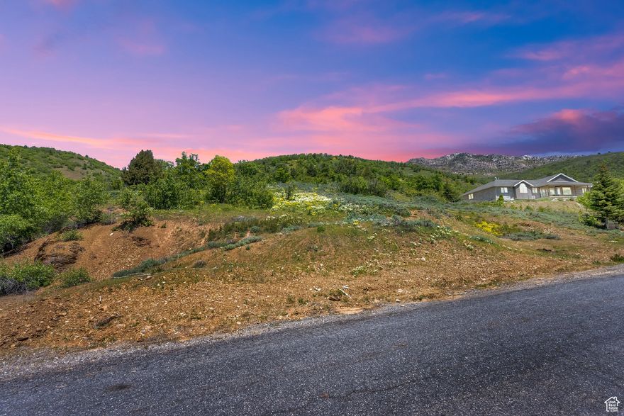 Imagine waking up every morning to a sweeping mountain view that feels like a private postcard from nature. This 2.65-acre lot in Huntsville's Green Hills community is more than just land-it's a lifestyle. Picture designing your dream home where you can sip coffee overlooking Snowbasin, with the soft sounds of the valley as your backdrop. The property's gentle slope makes it perfect for a custom mountain retreat, whether you're envisioning a grand estate or a cozy year-round getaway.  Life here is about balance-peaceful seclusion without isolation. You're only minutes from world-class skiing at Snowbasin and Powder Mountain, boating and paddleboarding on Pineview Reservoir, and an easy drive into Ogden for shopping, dining, and entertainment. The community has everything ready for you: paved roads, water, sewer, and power are already stubbed in, so you can focus on your vision, not logistics.  Green Hills residents enjoy access to walking and equestrian trails and even a private trout pond-perfect for quiet afternoons or teaching someone to fish. With low HOA fees that cover road maintenance and water, plus a friendly neighborhood vibe, it's easy to see why people love calling this valley home.  Build here, and you're not just buying a lot-you're claiming a piece of Utah's mountain magic.