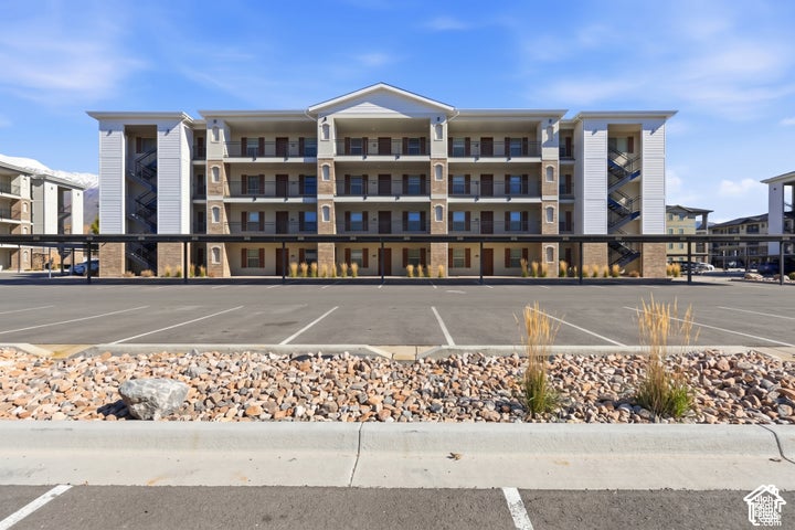 Multi-story exterior featuring stone veneer accents, lap siding, a gabled roofline, private covered balconies, and steel…