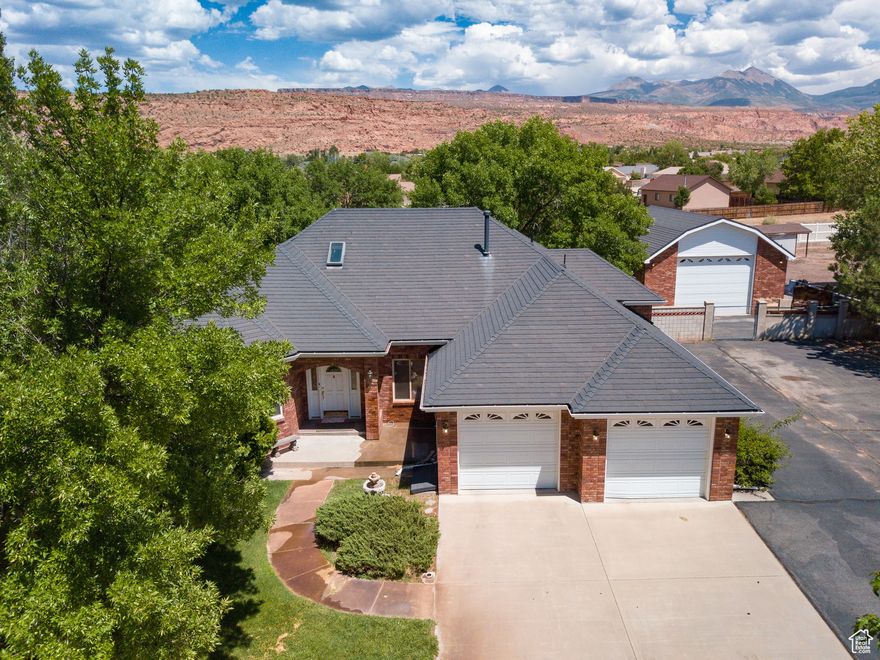 Beneath a canopy of mature trees, this well-maintained 4 bedroom, 2.5 bathroom residence spans over 4,000 square feet and is situated on a secluded one-acre estate beautifully landscaped with a circular driveway and views of the La Sal Mountains and Moab Rim. The main level offers a formal living room with a gas fireplace, a formal dining room, and a chef's kitchen. The entire upper floor is a master suite, featuring a jetted tub, a separate shower, a generous walk-in closet, and spectacular views of the backyard. The first lower level has three additional bedrooms, a complete bathroom, and laundry, and the second lower level has a spacious recreational room, is prepped for a wet bar, and is heated by a cozy wood-burning stove. The backyard has a garden, a fire pit, a basketball court, a tool shed perfect for storage, and a hot tub-ready patio. This is all complemented by a 28' x 34' detached shop plumbed for a bathroom as well as gas and includes a 240 bolt outlet. The property also includes paved parking and five acre-feet of Ken's Lake Irrigation Shares.