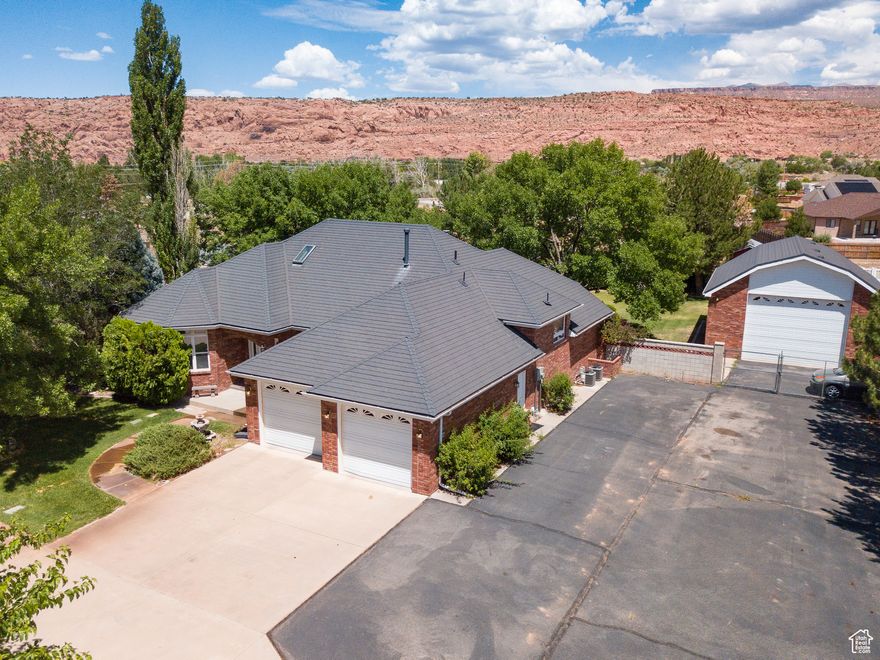Beneath a canopy of mature trees, this well-maintained 4 bedroom, 2.5 bathroom residence spans over 4,000 square feet and is situated on a secluded one-acre estate beautifully landscaped with a circular driveway and views of the La Sal Mountains and Moab Rim. The main level offers a formal living room with a gas fireplace, a formal dining room, and a chef's kitchen. The entire upper floor (sq ft unknown) is a master suite, featuring a jetted tub, a separate shower, a generous walk-in closet, and spectacular views of the backyard. The first basement level has three additional bedrooms, a complete bathroom, and laundry, and the second basement level (unknown sq ft) has a spacious recreational room, is prepped for a wet bar, and is heated by a cozy wood-burning stove. The backyard has a garden, a fire pit, a basketball court, a tool shed perfect for storage, and a hot tub-ready patio. This is all complemented by a 28' x 34' detached shop plumbed for a bathroom as well as gas and includes a 240 bolt outlet. The property also includes paved parking and five acre-feet of Ken's Lake Irrigation Shares.   Square footage figures are provided as a courtesy estimate only and were obtained from tax roll.  Buyer is advised to obtain an independent measurement.