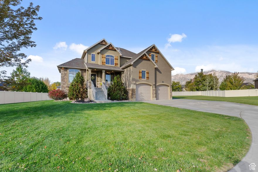 Beautiful two-story, stucco and stacked stone home that stands out from the rest of the neighborhood, sits on a large lot and offers a spacious, open floor plan with thoughtful design throughout.  Featuring 5 bedrooms and 4 bathrooms, this well-maintained property includes two formal entry spaces-ideal for a den, office, or additional living area. The main level flows seamlessly between living, dining, and kitchen areas, creating an inviting space for everyday living and entertaining with amazing views from the floor to ceiling windows. Step out to the covered back deck that can be enjoyed year round and enjoy beautiful views of Ben Lomond peak. Additional highlights of this home include a three-car garage with extra storage, basement theater room, mature landscaping, and a location that stands out for its distinctive style and generous lot size within the neighborhood.