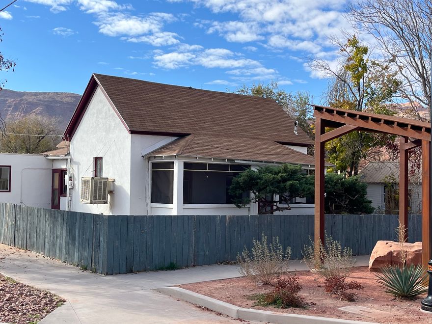 Turn-of-the-Century Charmer in the Heart of Old Town Moab. Discover a rare gem in Old Town Moab - a historic 3-bedroom, 1-bath residence just one block from Main Street and within easy walking distance to downtown shops, restaurants, and trails. This turn-of-the-century home exudes character with its thick plaster walls, stucco exterior, and timeless architectural details. Enjoy your mornings or unwind in the evenings on the inviting screened porch, perfectly positioned to take in the beautiful red rock views. The property sits on an R3-zoned lot, offering future flexibility and potential. Outside, you'll find established trees, a 1-car carport, and a spacious workshop with a durable metal roof - ideal for projects, storage, or creative pursuits. This is a rare opportunity to own a piece of Moab's history while enjoying unbeatable proximity to everything downtown has to offer. Sq footage is approximate. All info deemed reliable, but Buyer to verify all.