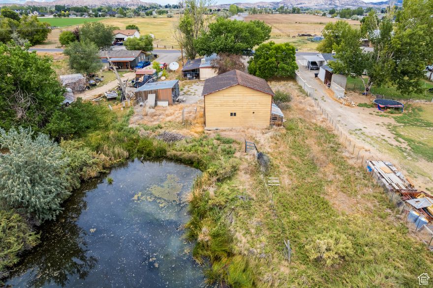 Discover the potential of this spacious lot, already equipped with water, power, and sewer-ready for your vision. The property features a large detached commercial garage, perfect for storage, hobbies, or projects, along with a beautiful pond at the back that adds both charm and a peaceful natural element to enjoy right from your backyard. While the existing mobile home is in poor condition, it could be renovated, or you may choose to remove it and build a brand-new home tailored to your needs. Conveniently located near town amenities, this property offers space, functionality, and endless possibilities. Being sold strictly AS-IS. Due to the home's condition and the pond, children should not be brought to showings. All parties enter at their own risk. Square footage per county records; buyer to verify all information.
