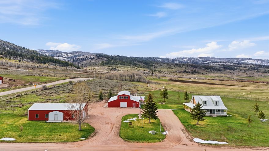 Escape to this stunning mountain retreat with room for everyone! The Bear Lake Ranch House offers a rare opportunity to own a spacious getaway that comfortably sleeps up to 32 guests, making it ideal for large gatherings or a high-performing short-term rental. With a strong rental history, this property is already set up to generate income while creating unforgettable experiences. The main home features 5 bedrooms and 3 bathrooms, designed for comfort and functionality with ample space to relax and entertain. The barn expands the property's versatility with a private owner's suite complete with its own bedroom and bathroom-perfect for on-site management while the property is rented. In addition, the barn includes 5 more bedrooms, 3 bathrooms, a kitchenette, laundry room, office, and a spacious gathering room offering incredible flexibility for guests or extended stays.  Surrounded by BLM land and endless riding trails, this property is a true outdoor enthusiast's paradise with direct access to wide open spaces and recreation right out your door. Enjoy breathtaking mountain views, privacy, and the peaceful setting this unique ranch offers. Located just 30 minutes from Bear Lake State Park, you'll have easy access to boating, fishing, and year-round adventure. The property is being sold fully furnished, making it completely turnkey and ready for immediate use or rental. A rare opportunity to own a large-capacity mountain retreat with proven income potential and unmatched access to the outdoors. Buyer and buyer's agent to verify all information.