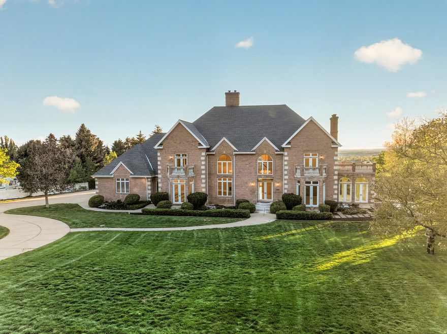 Exceptional custom estate crafted by Wilcox Construction set above Skyline Parkway on Ogden's coveted East Bench. Unobstructed sweeping panoramic views of the valley, Wasatch Front, and Great Salt Lake. Full-length windows on east and west elevations with remote motorized sun shades; Tray ceilings, hand-trimmed solid wood doors, 3/4" hardwood, Italian marble, adjustable LED lighting, custom cabinets and built-ins throughout add architectural distinction. Highlights include 11 chandeliers, a 1,100 sq ft deck, Wolf and Sub-zero appliances, 20'x40' pool with in-ground spa, four gas fireplaces, main-floor primary suite, and en-suite bathooms in every bedroom. Mostly unfinished lower level exceeds 4,000 sq ft with 10-ft ceilings, partial framing and plumbing roughed in. Approx.  acre of undeveloped, buildable rear acreage offers significant expansion potential. Oversized 4-car garage. Recent capital improvements include: new roof, two AC units, 100-gal water heater, water softener, RO system, sewage ejector pump, Rachio smart irrigation controller, Nest smart security cameras, thermostats, and smoke/CO detectors. Steps to Burch Creek Trailhead with direct trail access. Minutes to Weber State University and McKay-Dee Hospital. A rare caliber of offering on the Ogden bench. Square footage figures are provided as a courtesy estimate only. Buyer is advised to obtain an independent measurement.