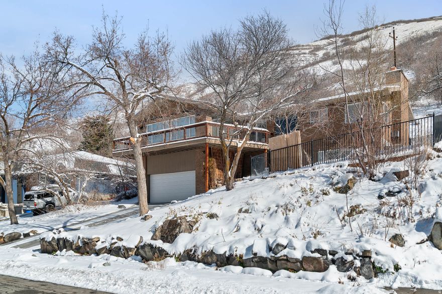 ***Open House this Saturday, Feb 28th, 10am-1pm*** Welcome to the coveted Top of the World neighborhood - nestled between Little Cottonwood and Big Cottonwood Canyons with Snowbird, Alta, Brighton, and Solitude ski resorts just minutes away. This is a rare opportunity to back up to quiet, open space while enjoying walking distance to Golden Hills Park and the neighborhood's new dog park. A nearby bus stop provides convenient canyon access to the ski resorts and other canyon activities. Ferguson Canyon trailhead sits practically in your backyard for hiking, trail running, and rock climbing. This beautifully updated 4-bedroom, 3-bath brick home occupies a quiet cul-de-sac with breathtaking mountain and valley views. Oversized windows flood every room with natural light and frame stunning panoramas from nearly every angle. The updated kitchen features granite countertops and a gas range, complemented by hardwood and stone flooring throughout. French doors and two fireplaces add warmth and character. The main level offers two bedrooms including the primary suite with en-suite bath and walk-in closet, formal living and dining areas, a spacious family room, and convenient laundry. Step onto the balcony to take in panoramic valley views - the perfect spot to unwind any time of day. The fully finished walkout basement provides two additional bedrooms, a three-quarter bath, and direct outdoor access. Outside, enjoy a private, fully fenced yard with mature trees and open patio. Newer furnace and a/c system, newer water heater, heated driveway, two-car attached garage, and ample additional parking complete the package. Downtown Salt Lake City is just 20 minutes via easy freeway access. Matterport 3D tour available. Square footage figures are provided as a courtesy estimate only. Buyer is advised to obtain an independent measurement.