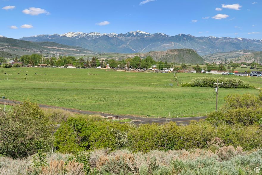 Enjoy sweeping rural valley views from this rare 12.01-acre parcel in the heart of the Kamas Valley, with sightlines that extend to nearby ski runs and the iconic Mount Timpanogos. Located just off Highway 35, this gently sloped and usable property offers a perfect balance of open space, privacy, and accessibility. Much of the tedious and time-consuming impact work has already been completed, including a graded driveway, building pad, and a private well drilled into pristine glacial water. Electric, gas, and internet are available at the front of the lot, streamlining the path to construction and saving valuable time and cost. Adding to its uniqueness, the land features rare Heritage Sandstone boulders that can be incorporated into a custom build, bringing natural character and charm. The property also presents a unique business opportunity: with the building envelope already in place, it could be the ideal setting for a corporate or wellness retreat. The expansive acreage, unobstructed views, and serene surroundings offer a compelling backdrop for a destination retreat or creative live-work concept. The Uinta National Forest is just minutes away, offering year-round outdoor recreation including hiking, horseback riding, snowmobiling, and backcountry skiing. Whether you're planning a private mountain estate, a family compound, or an income-generating retreat, this lot provides freedom and flexibility with no HOA restrictions. Just minutes to downtown Kamas, 20 minutes to Park City, and under an hour to Salt Lake City, this property is an exceptional opportunity in one of Utah's most scenic and desirable regions.