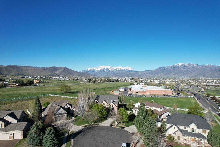 Placed on the best view lot in the sought-after Cobblestone neighborhood -- with community open space, walking trails, parks, and convenient proximity to schools and churches -- this exceptional home offers a setting that's hard to beat. The main level delivers elevated living with incredible Timpanogos views, a master suite featuring a large walk-in closet and separate tub and shower, an open great room anchored by an marble fireplace, double ovens, gas stove, sunroom, mudroom, and dedicated laundry. Upstairs offers two bedrooms, a full bath, and a bonus room. The lower level functions as a complete second living space -- two bedrooms, full bath, kitchen, great room with fireplace, and semi-formal dining, ideal for multigenerational living or guests. Thoughtful mechanicals include solar panels, tankless water heater, water softener, four-zone HVAC, and radon mitigation. Finishing touches like an imported front door, epoxy garage floor, and a pergola with outdoor dining area speak to the care put into every detail. Best of all -- enjoy unobstructed views of Mount Timpanogos, the finest in the neighborhood, from a home that adjoins the schoolyard for added open space and privacy.