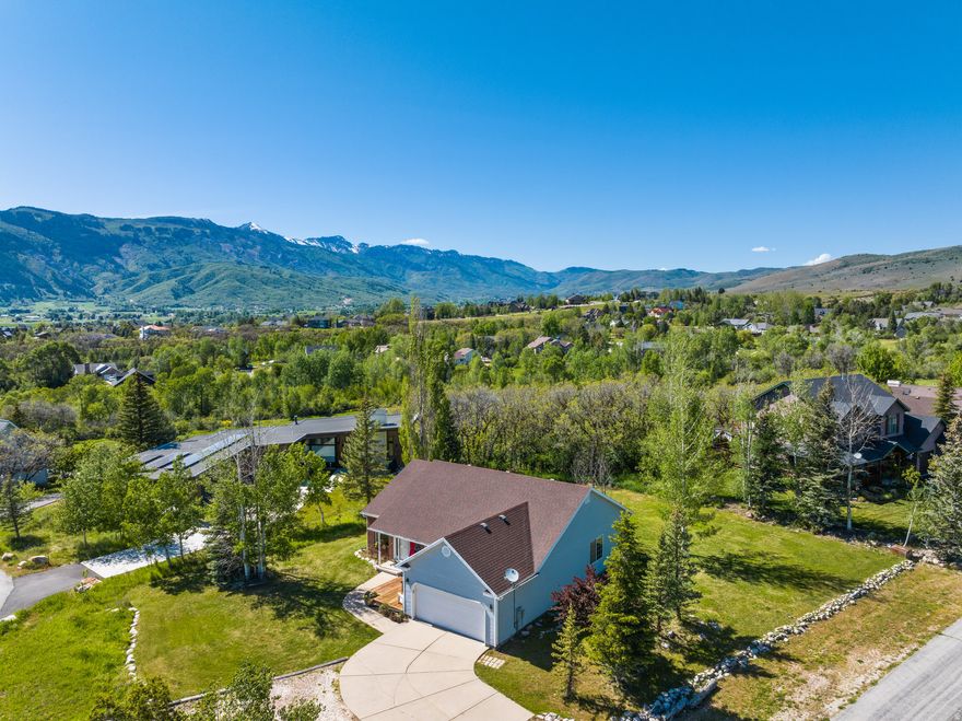 Perched against protected land with sweeping valley views, this exceptional home captures direct views of Pineview Reservoir and the iconic peaks of Snowbasin. Built for comfort and scenery, the property offers incredible outdoor living with excellent landscaping with mature trees. Inside, the home features a spacious kitchen and an excellent office that can also be used as a bedroom. The office comes with a custom desk, that gives one of the best office views in the area! Downstairs, you'll find a bright basement with a separate living area for entertaining or guest space. Large windows throughout the home bring in natural light and frame the stunning mountain and valley views from multiple angles. With a seamless blend of indoor comfort and outdoor beauty, this home offers a rare opportunity to enjoy mountain living at an attractive price point. The home sits just below the Wolf Creek Resort, and is less than 10-minutes from Powder Mountain, 20-minutes from Snowbasin, and centrally located to all the area has to offer.