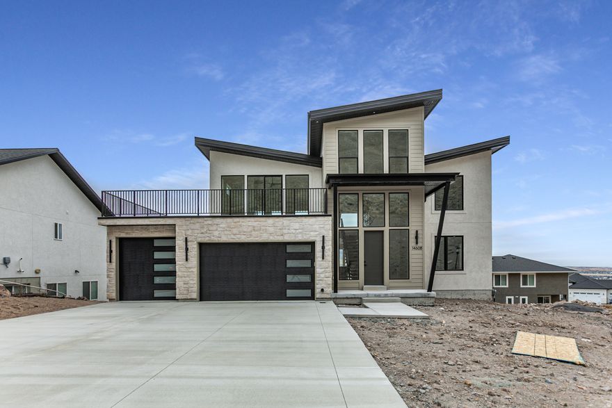 Ready for you to move in! Designed to impress, this exceptional home delivers million-dollar views and elevated living at every turn. Thoughtfully crafted for main-floor living, the heart of the home features an induction cooktop, a hidden walk-in pantry, and a lovely dining room perfect for hosting unforgettable gatherings. The primary suite is a true retreat, complete with the ultimate convenience-laundry located directly in the walk-in closet. A striking floating staircase with wood treads leads to the second level, where a princess-elevated bedroom captures breathtaking vistas, alongside a spacious recreation room, wet bar, and a private sundeck perched above the garage-ideal for sunsets and stargazing. The finished garage includes a functional mudroom and built-in storage shelves to keep life organized. Downstairs, the full walkout basement is flooded with natural light thanks to above-ground windows and panoramic views, offering endless possibilities for living or entertaining space. A cold storage room adds practicality to this beautifully designed level. Basement could be finished with an ADU ~ 2 bedrooms, kitchen, bath and large living space! Modern, elegant, and surrounded by unforgettable scenery-this is more than a home, it's a lifestyle.