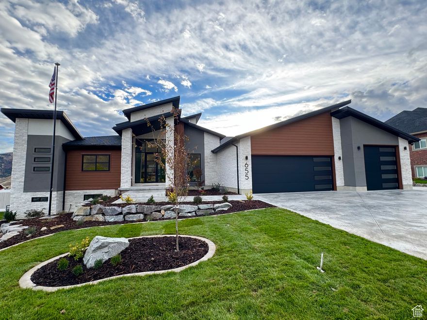 Dream home with heated shop in dream location! This FEATURE PACKED home boasts a contemporary design in this HIGHLY coveted mountain valley town. Landscaping is complete. 30 minutes from Ogden and 1 hour north of SLC Int'l airport!  Sits 1 mile north and south  of the gorgeous Mantua reservoir and the beautiful Willard Peak canyon popular for camping, hiking, and atv's.  Only  8 minutes to Brigham City for shopping, schools, and city amenities. This impressive home faces a STUNNING mountain view.  The properties in front of this home are protected 5 acre lots of mostly farmed land.  Your view is protected! THE ENTIRE DRIVEWAY IS PRE-PLUMBED FOR HEAT! YES!! Piping begins at the front entry stoop and wraps around property to the back yard deck. Amazing rare upgrade! This home also boasts a modern open concept with authentic Herman Miller designer lighting in foyer and office, oversized glass sliding door/windows, multiple family rooms, contemporary kitchen with huge granite waterfall island, modern cabinetry, and gorgeous butler pantry, whole house automatic generator, whole house attic fan, 300 gallon water storage tank piped into homes water system, huge custom steam shower in master with heated floor and bench, master bathroom fully heated floor with bidet toilet, massive 10x10 custom built dry sauna off the gym, 2 furnaces, 2 instant on demand hot water heaters, water softener, water filtration, permanent holiday lighting (Trimlight) on roof lines and under back patio, hot tub, 2 gas fire pits, large concrete pad ready for shed or pergola, pre-wired theater/gaming room, all rooms wired with coax cable and CAT6 ethernet, Brilliant Smart Home System, Ring cameras oversee property, oversized and finished epoxied 3 car garage pre-wired for 2 EV chargers, 40x50 HEATED SHOP plumbed with sewer and water, finished daylight walk-out basement pre-wired and pre-plumbed to be a separate living space if desired. Landscape update: Trees, shrubs, plants, full sprinkler and soaker system installed. Sealed concrete curbing, decorative bark, top soil, and sod installed. Do not miss this RARE gem!