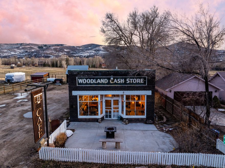 OPEN HOUSE FEBRUARY 28TH 1-3.   Well-maintained and full of character, this standalone commercial property offers a rare opportunity for a restaurant, cafe, event venue, or specialty food concept. Established in 1930 and operating as a cafe since 2015, the historic Woodland Cash Store enters a new chapter in 2025, continuing its legacy as a cherished community gathering place. The inviting storefront features classic brick construction, prominent signage, and excellent street presence, creating strong curb appeal and visibility.  Inside, the space opens to a warm and welcoming dining area with abundant natural light, polished concrete floors, and thoughtful finishes throughout. The flexible layout comfortably accommodates multiple seating arrangements, making it ideal for dine-in service, private events, or experiential retail use. Tasteful built-ins and dcor preserve the building's historic charm while maintaining a clean, professional aesthetic.  The commercial kitchen is fully equipped with stainless steel appliances, vent hood, gas range, prep space, and ample storage-designed for efficient workflow and ready for immediate operation.  Whether you're an owner-operator or investor, this turnkey property offers both functionality and atmosphere, providing a unique opportunity to operate within a space rooted in history while supporting modern commercial use. All property information, boundaries and documents to be verified by buyer.