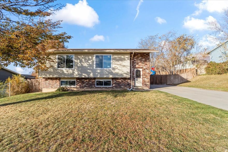 This beautiful home offers the perfect blend of comfort, function, and style. The spacious, fully fenced backyard features a mature apple tree and plenty of room to relax or entertain. Inside, the kitchen shines with stainless steel appliances, and the primary bedroom includes a walk-in closet for added convenience. With two bedrooms upstairs and two more downstairs, the layout offers flexibility for guests, office space, or a growing family. The large basement living room is a cozy retreat with a fireplace and built-in shelving that adds charm and practicality.  Recent updates make this home truly move-in ready. In 2021, new carpet was installed in the upstairs bedrooms, followed by new basement flooring in 2022. In 2023, new windows and a sliding glass door were added, improving both energy efficiency and aesthetics. The kitchen was further updated with a new fridge and stove in 2024, and a new microwave and garbage disposal were installed in 2025-all included in the sale.  Conveniently located near grocery stores, restaurants, and schools, this home offers the ideal mix of peaceful living and easy access to everyday essentials. With its inviting spaces, thoughtful upgrades, and serene outdoor setting, this home checks all the boxes. Don't miss your chance to make it yours-schedule your private tour today! Square footage provided as a courtesy and was obtained from county records. Buyer is advised to verify all information.