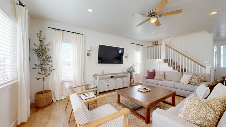 Open-concept living space with wood-finish flooring, recessed lighting, and a ceiling fan