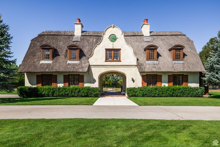 Nestled in a secluded, gated community at the foot of the majestic Cottonwood Canyons, this rare two-acre property offers the perfect blend of privacy, craftsmanship, and potential. With convenient access to nearby amenities and the freeway, it provides both seclusion and connectivity.  Originally envisioned as a gatehouse for a 38,000 sq ft estate on 14 acres, this exquisitely crafted home stands as a testament to unmatched artisanal skill. Designed by renowned architect David Easton, the Cape Dutch-style cottage features an authentic thatched roof-an architectural rarity-and extraordinary attention to detail throughout.  Inside, custom millwork, hand-forged hardware, and elegant marble bathrooms showcase the dedication poured into every inch of the home. The great room boasts handcrafted beams and expansive windows framing panoramic views of Mt. Olympus and Big Cottonwood Canyon, opening seamlessly to a lush, private garden.  Upstairs, two bedroom suites-each with its own fireplace and en-suite bath-offer a serene and luxurious retreat. Additional features include vaulted ceilings with intricate woodwork, a kitchenette, wet bar, and built-ins throughout. The unique cobbled Sally Port leads to a heated garage and workshop, while a beautifully restored historic barn adds a touch of rustic charm.  Behind two private gates, this one-of-a-kind estate offers room for future expansion or creative development-making it a truly flexible legacy property. The lore of the carpenter who lived on-site in a sleeping bag for over a year speaks to the passion and dedication behind the home's construction.